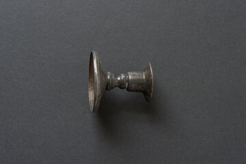 close up of an isolated silver candle stick holder on dark grey