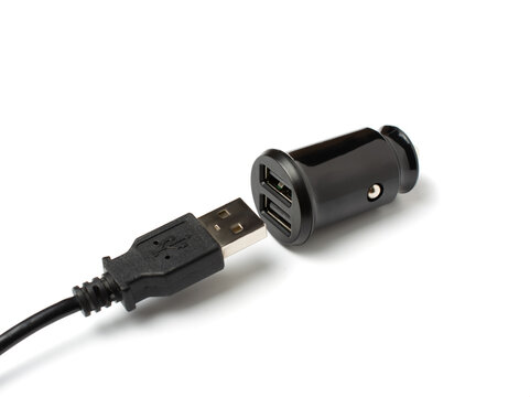 USB wire and black car charger with two USB ports, multifunctional cigarette lighter adapter plug. white background.