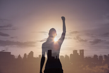 Strong victorious woman with fist in the air facing the city. People power, and hero concept. 