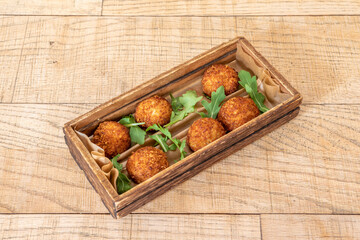 Tapa of Iberian croquettes with a little arugula in a curious wooden tray