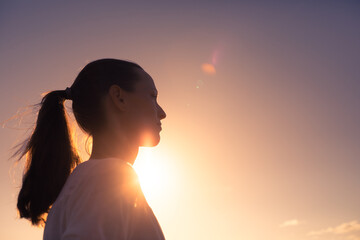 Life is beautiful. Woman standing facing a beautiful golden sunrise.	