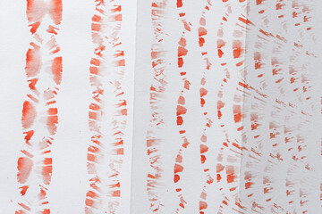 wet and dry bristle-haired brush dipped in cadmium red orange medium watercolour paint pattern on white sketchbook paper - background  
