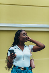 Fototapeta premium Cheerful african american woman using smartphone