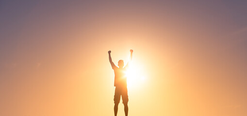 silhouette of man putting fist up in the air. People feeling strong, winning and victory concept. 