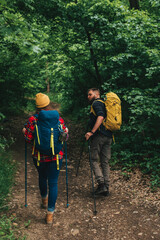 Hikers using trekking poles while wearing backpacks with a camping gear