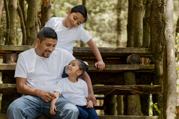 Hispanic dad and sons enjoying nature in the park - Young father with his children outdoors having...