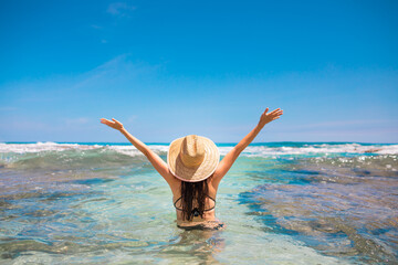 Happy young woman on tropical beach lifting arms up to the sky. Summer holiday , and people enjoying nature concept. 