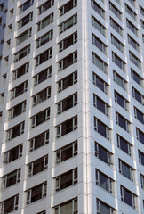 close up the corner of a modern apartment building with geometric metallic cladding and repeating pattern windows