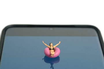 Miniature people toy figure photography. Virtual travel concept, girl swimming with rubber tube...