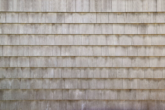 Dry aged weathered cedar shingle siding texture on an old summer cottage home building