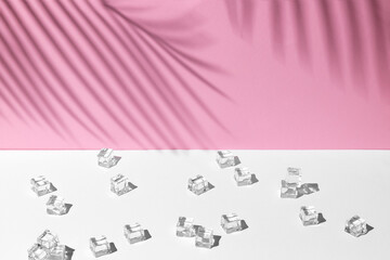 summer mockup with white and pink pastel colors. many ice cubes at midday sun and hard shadows from palm leaves at the background for copy space