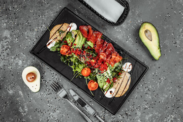 Salmon salad gravlax. Smoked salmon salad, with mixed greens, cherry tomatoes, avocado, black olives, carrots, sprouts, cucumber, and lime. Delicious healthy eating