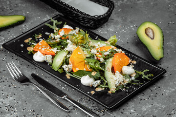 Fresh salad with fruits and greens on dark canvas background. Healthy food