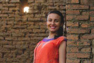 Portrait of brunette Mexican woman smiling in an old construction made of clay bricks