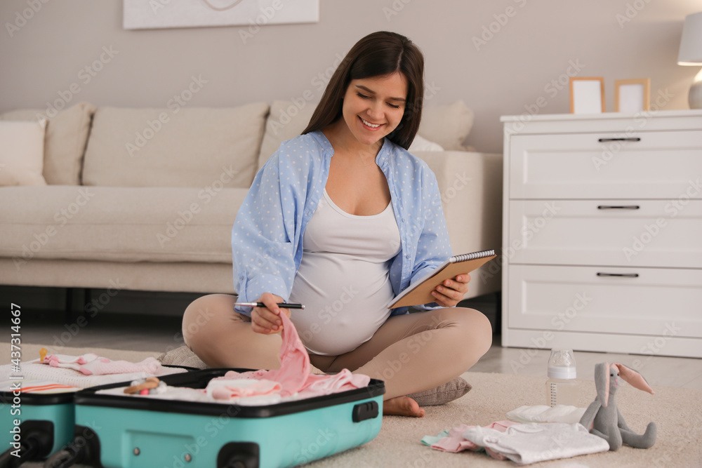 Canvas Prints Pregnant woman packing suitcase for maternity hospital at home