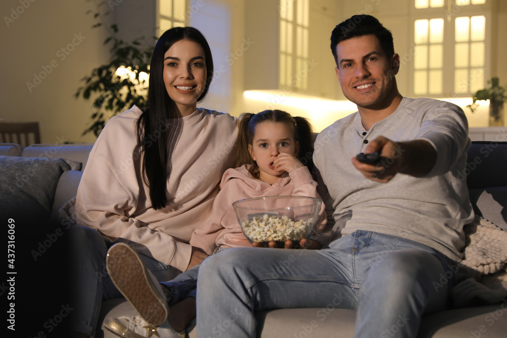 Sticker family watching movie with popcorn on sofa at night