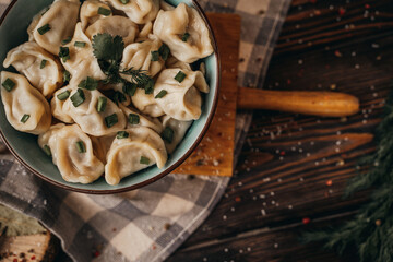 Boiled dumplings in a deep bowl, sprinkled with fresh green onions