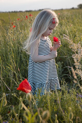 Candid portrait of happy toddler girl on a poppy field