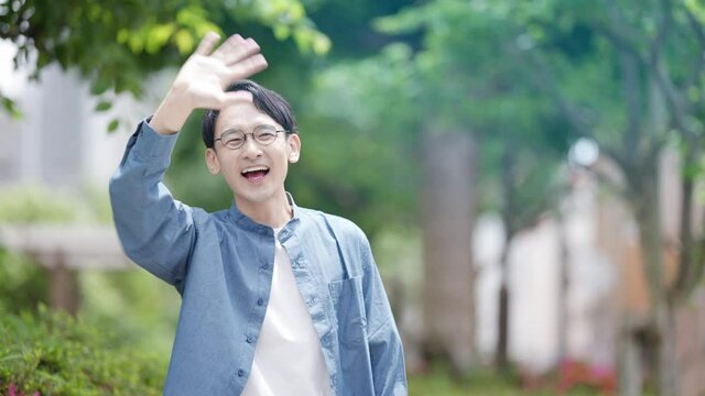 友人と待ち合わせをしている若い男性