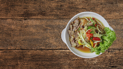 Som Tum or Thai spicy fresh young papaya salad with grilled beef