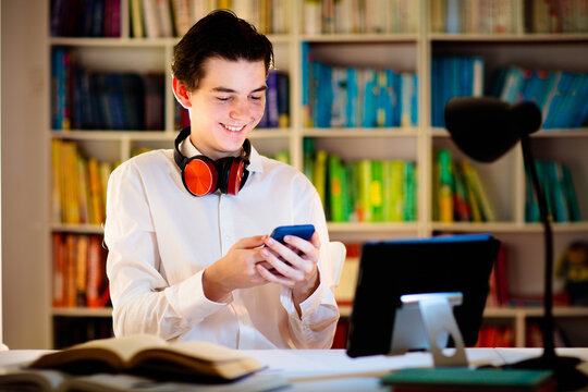 Teenage Student At Laptop. Teenager With Phone.