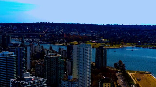 Vancocuver English Bay Aerial flyover beaches are empty with nobody out during a lockdown COVID-19 Pandemic on top of the residential high rise condominiums apartment buildings and just one motor boat