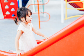 公園の遊具で遊ぶ小さな女の子