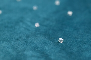 Several large faceted diamonds lie on the blue velvet. Close-up photo