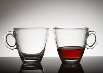 two classes: one is empty, the second one is half with tea 