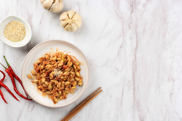 Korean Dish: Kongnamul Muchim, One Various of Spicy Korean Side Dish (Banchan). Kongnamul is Mung Bean Sprout. Top View on Marble Table with Copy Space for Text