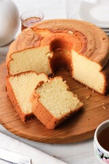 Slice of Fluffly Vanilla Chiffon Cake or Sponge Cake on Black Stone Plate, Served with Tea and Honey. Bright Food Photography Concept for Bakery