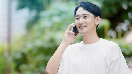 屋外で電話をする若い男性