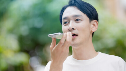 Fototapeta premium 屋外で電話をする若い男性