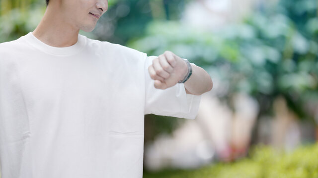 友人と待ち合わせをしている若い男性