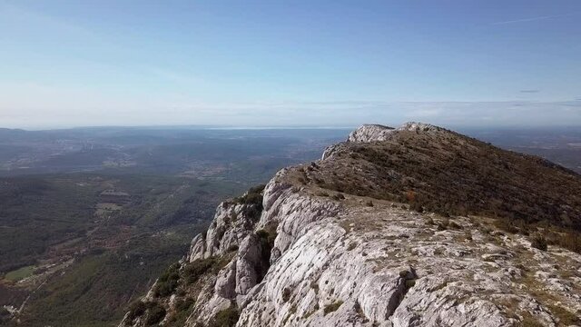 Flying close to a mountainous rocky outcrop high above St. Victoire, Aix en Provence, France, aerial