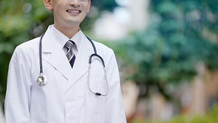 木を背景に立っている医者