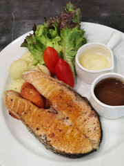 Fish steak with mashed potato and salad on the plate