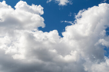 Fluffy cumulus clouds on blue sky close-up