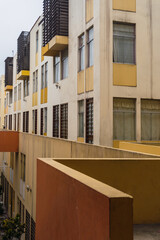 Obraz premium Aged facade of modern multi - storey colored residential building in historic center of Lima Peru, yellow and orange walls, trees.