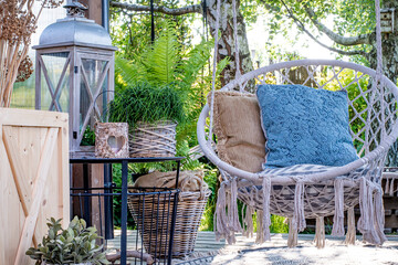 Fototapeta Miejsce wypoczynku w ogrodzie, taras z huśtawką w stylu boho, miejsce na kawę i książkę na świeżym powietrzu obraz