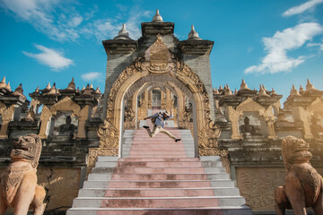 Happy Asian man traveler jumping in the attraction beautiful architecture art of south East Asian culture. Travel south east Asia.