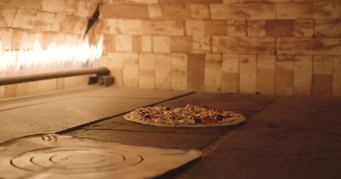 Arabic Pizza cooking in a brick oven with flames lighting up