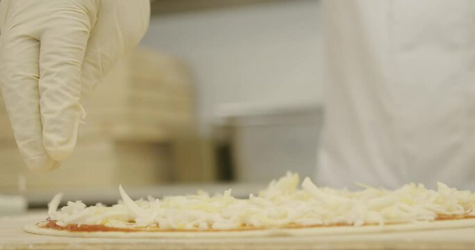 Sprinkling cheese on top of manakish Arabic food or pizza