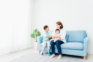 家で子どもたちと遊ぶ若い主婦