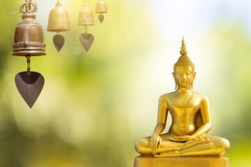 Gold Buddha statue with antique thai style bell over blurred background, culture and religion concept, buddhism symbol