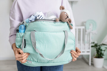 Woman with bag and baby bottles at home