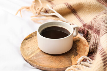 Cup of coffee and plaid on bed
