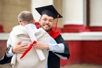 Happy young man with his father on graduation day