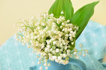 Vase with beautiful lily-of-the-valley flowers on table, closeup