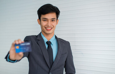 Naklejka premium Cheerful Asian businessman advertising credit card
